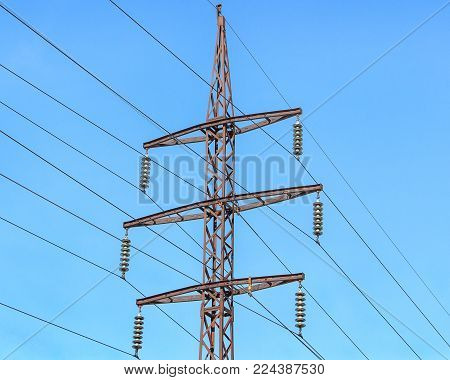 Metal support (elektroopora) of overhead power lines against a blue sky.