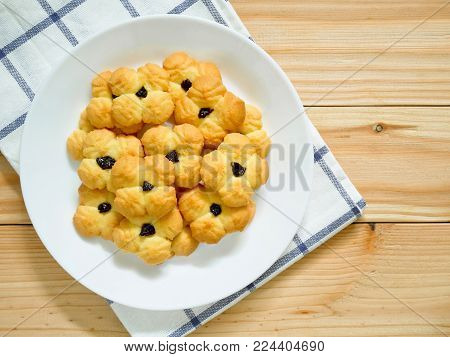 Plie of butter cookies with raisin on white plate with copy space