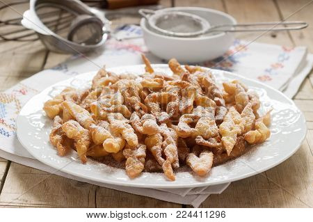 Angel wings biscuits, a traditional European sweet dish for carnival. Rustic style, selective focus.