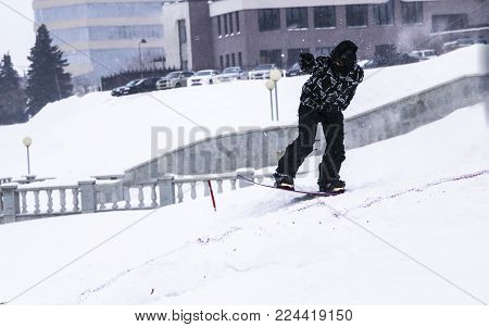 snowboarding. jump on snowboard. freestyle. jump from a springboard on a snowboard in the city. Grab. free ride