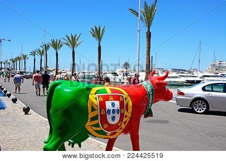 VILAMOURA, PORTUGAL - JUNE 6, 2017 - Bull statue painted in red and green with the Portuguese national football team logo on the side in the marina area, Vilamoura, Algarve, Portugal, Europe, June 6, 2017.