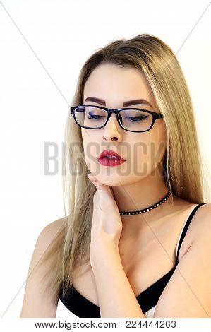 Charming blonde with glasses on a white wall background, red sexy lips and a mysterious look