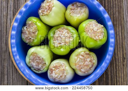 Raw Peppers Stuffed With Meat On A Wooden Cutting Board