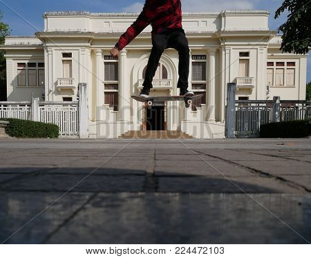 Skateboarder Skate & Jump Outdoors In Front Of Beige Building. Man On Skateboard. Sport Leisure Life