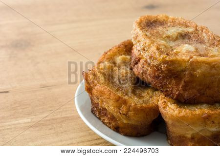 Traditional homemade Spanish torrijas on wooden background. Easter dessert.