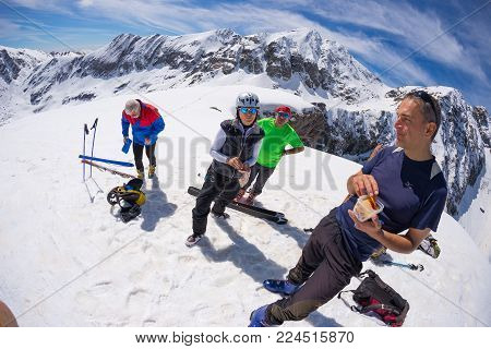 Group Of Alpinists Selfie On Mountain Top. Scenic High Altitude Background On Snow Capped Alps, Sunn