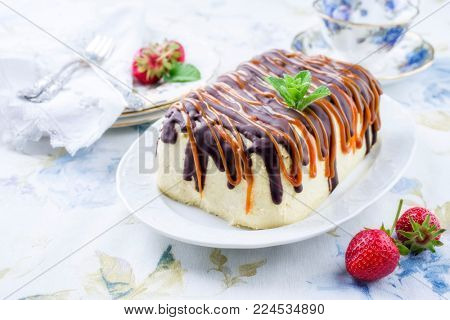 Traditional chocolate caramel cheesecake with fresh strawberries as top view on a plate 