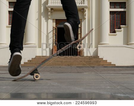 skateboarder skate & jump outdoors in front of beige building. man on skateboard. sport leisure lifesyle concept.