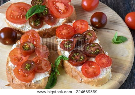Sandwich with butter, tomatoes and basil. Close up