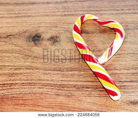 candy in the shape of heart on a wooden background for the celebration of Valentine's Day. The celebration on February 14 likes decorated candy. Valentine's Day