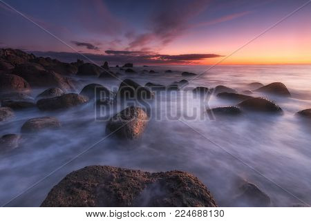 Sunrise over a calm sea at Arribolas beach in Bermeo, Bizkaia