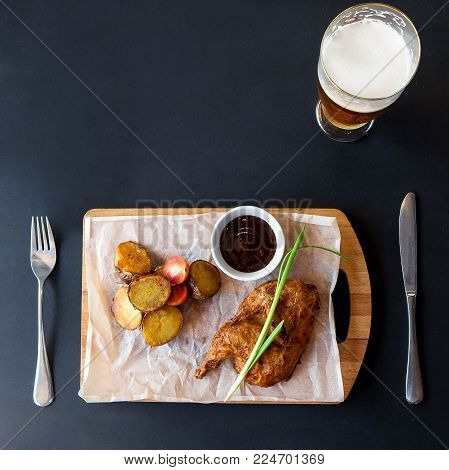 Chicken nuggets, fried potatoes, beer and sauce. Top view