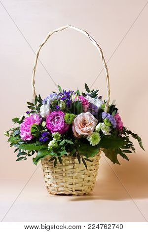 Beautiful bunch of different flowers in basket, selective focus and blurred background