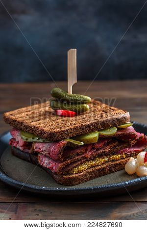Close view of beef pastrami sandwich on wooden board