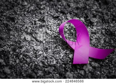 Purple ribbon awareness on dark background  for World Cancer day.
