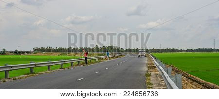 Tien Giang, Vietnam - Aug 31, 2017. People Walking On Rural Road In Tien Giang, Mekong Delta, Vietna