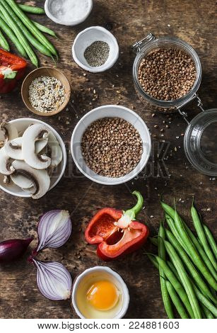 Flat lay healthy vegetarian food ingredients for lunch on a wooden background, top view. Buckwheat, green beans, sweet peppers, red onion, mushrooms, egg - clean eating vegetarian food concept
