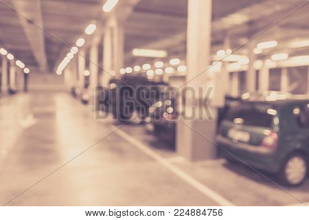 Blurred image/ Parking garage - interior shot of multi-story car park, underground parking with cars.