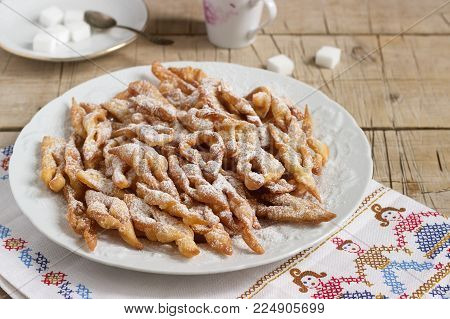 Angel wings biscuits, a traditional European sweet dish for carnival. Rustic style, selective focus.
