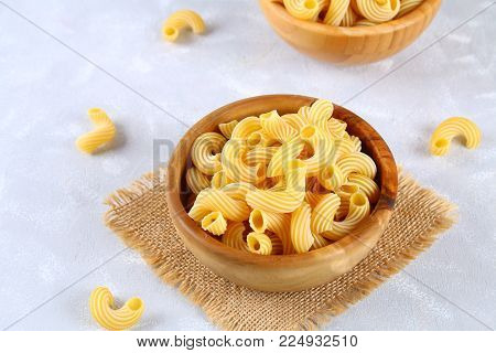 Raw Pasta Cavatappi or Cellentani on a gray table