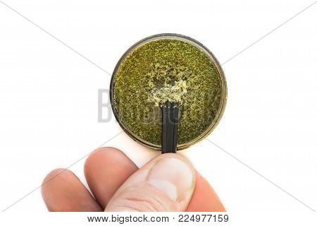 Kief in grinder for weed Trichomes buds of Cannabis And the hands of men macro top view isolated on white background
