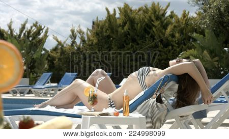 Beautiful young woman enjoying sunny weather by swimming pool, summer vacation HD