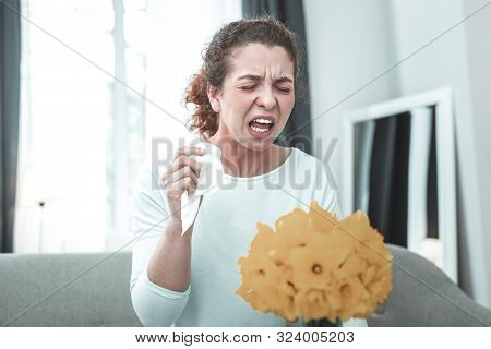 Mature Woman Sneezing While Having Allergy To Flowers