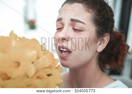 Red-haired Woman With Ponytail Sneezing After Smelling Flowers
