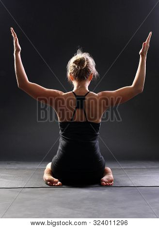 Young Woman Wearing Black Sportswear Practicing Yoga, Doing Asana Hero Pose. Sitting Between The Kne
