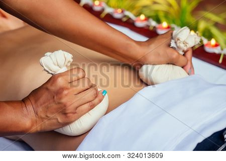 Portrait Of Young Beautiful Woman Lying On A Wooden Table In Spa Environment Flowers And Candles