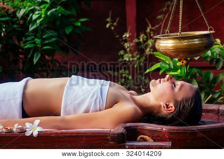 Ayurveda Massage Alternative Healing Therapy.beautiful Caucasian Female Getting Shirodhara Treatment