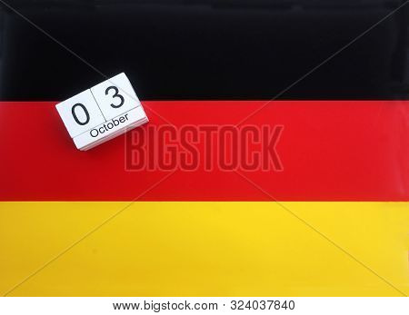 Wooden Cubes With The Date Of The Day Of German Unity, 3 October, Lying On A German Flag
