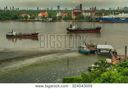 Bangkok, Thailand - 05 Aug 2019 : Cargo Ships In The Middle Chao Phraya River And The Back Is Green 