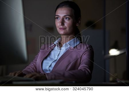 Young Beautiful Secretary Sitting At The Table Looking At Computer Monitor And Typing On Computer Ke