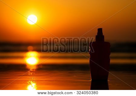 Copyspace Spf Sunscreen Sun Block Bottle On The Sand By The Sea Shore. Sunset Viagra Oil Erotic Mass
