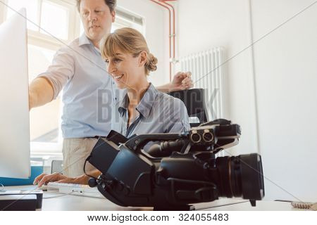 Woman and man working on a video in post-production on the computer