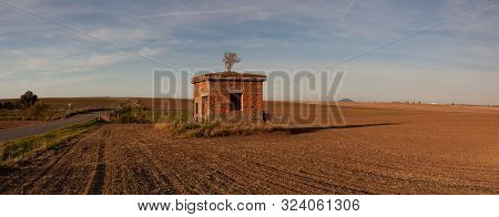 Old Ruin Electricity Substation On The Empty Field. The Field After Harvesting In Sunny Day.czech Re