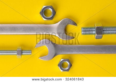 Wrench And Nuts With Bolts. Wrench And Nuts With Bolts On A Yellow Background. Wrench And Bolt With 