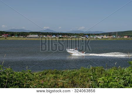 Yuzhno-sakhalinsk, Russia-august 27, 2019. 3 Men And A Woman Moving On A Speedboat On The Dust Krasn