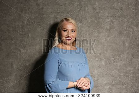 Portrait Of Beautiful Mature Woman On Grey Background