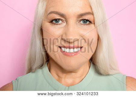 Portrait Of Mature Woman With Beautiful Face On Pink Background