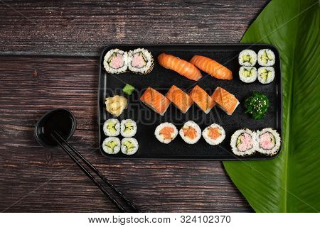 Sushi Set Of Nigiri, Maki Rolls And Wakame Salad Served On Stone Plate On Wooden Background. Japanes