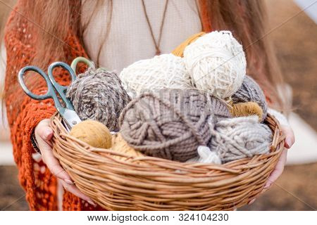 Skeins Of Thread With Combs In A Basket, Close-up. Sewing Tools, Wooden Sticks For Knitting.