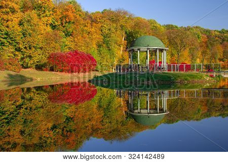Evening In The Autumn City Park.
Trees Are Reflected In The Pond. Ukraine, Kyiv. 
