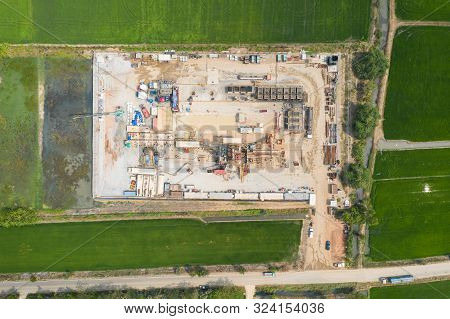 Oil And Gas Land Drilling Rig Onshore In The Middle Of A Rice Field Aerial View From A Drone