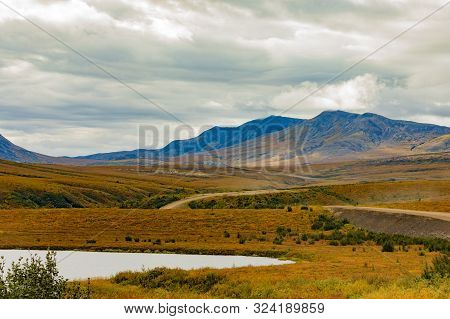 Dempster Highway Crossing Autumn Colors Of Arctic Tundra Landscape Of Richardson Mountains In Northw