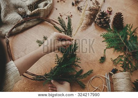 Christmas Wreath Workshop. Hands Holding Herbs, Fir Branches, Pine Cones, Berries, Thread, Scissors 