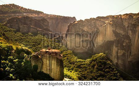 Monastery Meteora Greece. Stunning  panoramic landscape. View of mountains and green forest against epic blue sky with clouds. UNESCO heritage object.