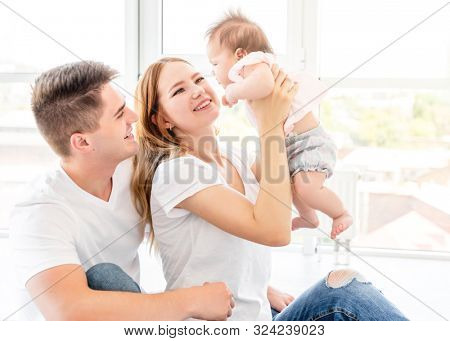 Parents holding up baby, view from above