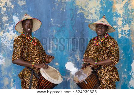 A Group Of People In Traditional African Costumes Playing Jembe Drums